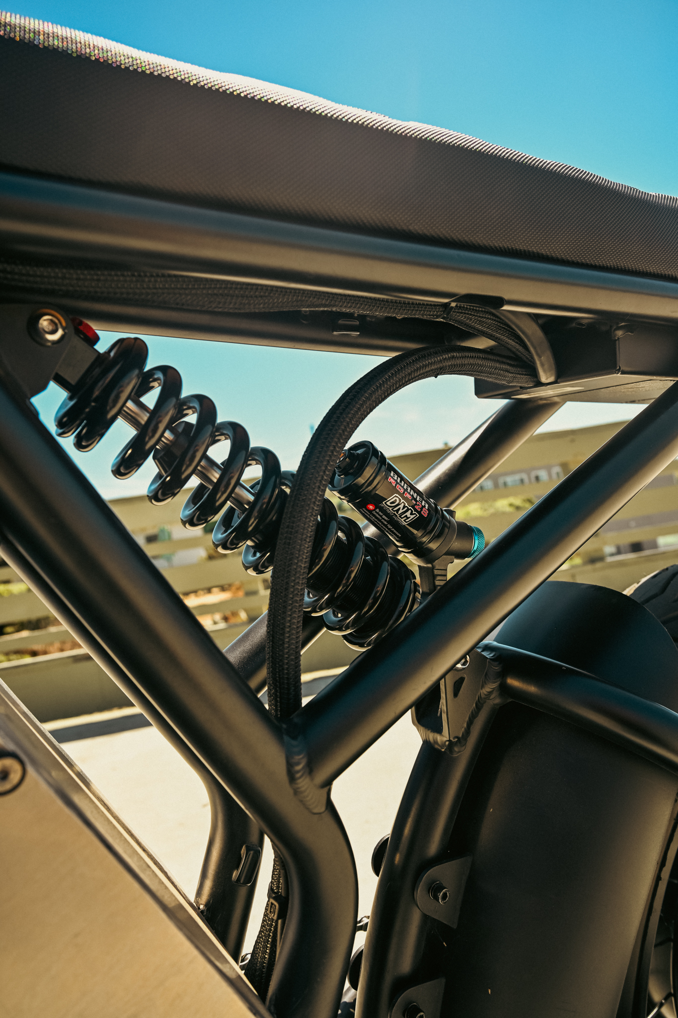 DNM Burner RCP-2S rear shock visible through the bike frame triangle with braided wiring routed neatly